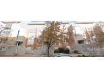 Attractive three-story townhome featuring brick accents, multiple windows, and well-maintained landscaping at 521 Donatello Ave, Charlotte, NC 28205