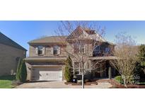 Charming two-story brick home featuring an attached two-car garage and well-maintained landscaping at 5633 Open Book Ln, Charlotte, NC 28270