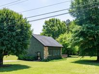 Charming home with green siding, stone accents, and lush landscaping in a peaceful setting at 7728 Babe Stillwell Farm Rd, Huntersville, NC 28078