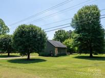 Charming home featuring green siding, stone accents, and a well-maintained lawn at 7728 Babe Stillwell Farm Rd, Huntersville, NC 28078