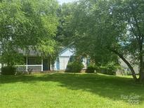 Charming single-story home with inviting front porch and lush, green lawn, shaded by mature trees at 8122 Cadmium Ct, Charlotte, NC 28215