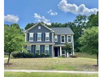 Two-story home featuring a well-manicured lawn and beautiful blue siding at 8268 Breton Way, Harrisburg, NC 28075