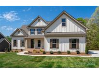 Beautiful home featuring a bright white exterior, charming brown shutters, and a well-manicured front yard at 104 Wilharr Ct # 40, Mooresville, NC 28115