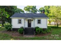Charming single-story home with black stairway, manicured bushes, and mature trees at 116 Barnes Ln, Stony Point, NC 28678