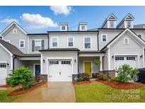 Charming townhome with a one-car garage, yellow front door, and nicely landscaped front yard at 12021 Basking Dr, Charlotte, NC 28214