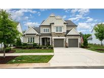 Charming two-story home features stone accents, a two-car garage, and manicured landscaping at 13602 Huntson Park Ln, Huntersville, NC 28078