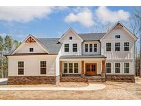 Charming two-story home with stone accents, a covered porch, and a well-manicured lawn at 206 Streamwood Rd # 32, Troutman, NC 28166
