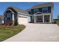 Charming two-story home featuring stone accents, a two-car garage, and a well-manicured front lawn at 2068 Fordhill St, Rock Hill, SC 29732
