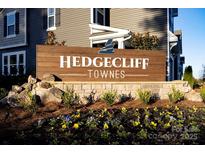Welcoming entrance sign for Hedgecliff Townes, adorned with colorful flowers and lush landscaping at 2450 Hedgecliff Rd, Kannapolis, NC 28025