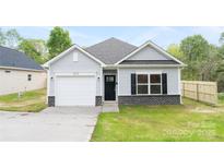 Charming one-story home with light gray siding, black shutters, and a one-car garage at 401 Groves St, Lowell, NC 28098