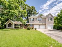 Charming two-story home with a three-car garage and a large, well-maintained front lawn surrounded by mature trees at 4325 Wolf Pond Rd, Monroe, NC 28112