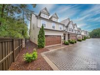 Charming townhome with a two-car garage, landscaped yard, and brick-paved driveway at 5918 Barrowlands Ct, Charlotte, NC 28210
