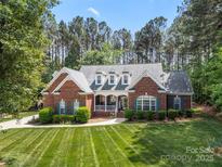 Beautiful brick home with manicured lawn, mature trees and charming curb appeal at 6990 Ridgeway Rd, Stanley, NC 28164