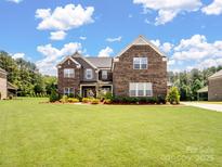 Beautiful two-story brick home featuring a large front yard and well-maintained landscaping at 709 Cavesson Way, Monroe, NC 28110