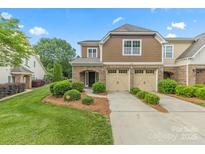 Charming townhouse with a two-car garage, landscaped front yard, and covered entryway, offering curb appeal at 8505 Loxton Cir, Charlotte, NC 28214