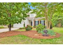 Charming two-story home with stone accents, a well-manicured lawn, and a beautifully landscaped front yard at 8938 Kestral Ridge Dr, Charlotte, NC 28269