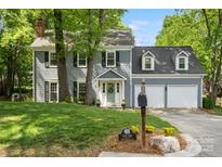 Charming two-story home with a well-manicured lawn, two-car garage and lovely landscaping at 9238 Deer Spring Ln, Charlotte, NC 28210