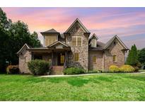Stunning two-story brick and stone home with manicured lawn and mature landscaping at 1010 Nutall Oak Ln, Belmont, NC 28012