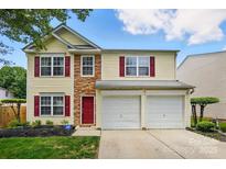 Charming two-story home with red door, brick facade and a well-manicured front lawn at 10431 Plantain Ct, Charlotte, NC 28213