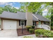 Charming home featuring a neutral color, green door, well-maintained landscaping, and attached garage at 11102 Sundown Ln, Charlotte, NC 28226