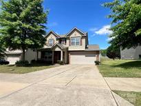 Two-story home with neutral siding, red shutters, a two-car garage, and a well-maintained lawn at 11505 Sweetbriar Ridge Dr, Charlotte, NC 28269