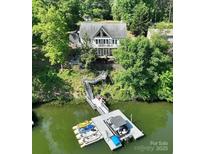 Lakefront home with private dock, multiple boats, and lush greenery surrounding the property at 126 Strand Rd, New London, NC 28127