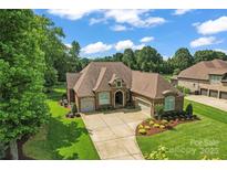 Stunning brick home with a three-car garage, professional landscaping, and a spacious driveway at 1400 Delaney Dr, Matthews, NC 28104