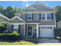 Charming two-story home features gray siding, blue shutters, a well-kept lawn, and an attached one car garage at 14010 Pinyon Pine Ln, Charlotte, NC 28215