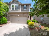 Charming two-story home with a brick facade, inviting front yard, and two-car garage at 14506 Knowledge Cir, Charlotte, NC 28277