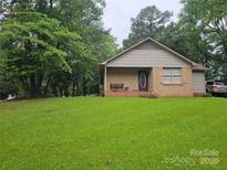 Charming single-story brick home with a well-maintained lawn and inviting front porch at 1700 Old Towne Ct, Charlotte, NC 28217