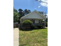Charming single-story home with a cozy front porch and well-maintained lawn and manicured shrubbery at 201 Easy St, Concord, NC 28027