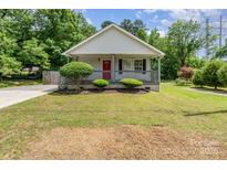 Charming single-story home with a welcoming porch, red front door, and well-maintained front yard at 201 Easy St, Concord, NC 28027