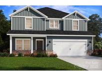 Charming two-story home featuring vertical siding, multiple windows, a two-car garage, and a well-maintained lawn at 2149 Sunflower Cir, Newton, NC 28658