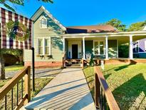 Charming home with green siding, inviting porch, and walkway, plus a welcome sign, all under a sunny, blue sky at 222 Brevard St, Statesville, NC 28677