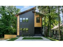 Modern home featuring dark siding, wood accents, and ample windows at 2224 Highland St, Charlotte, NC 28208