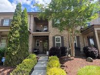 Charming townhome with brick facade, landscaped yard, covered porch and upper balcony at 2279 Eversham Nw Dr, Concord, NC 28027