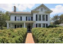 Charming two-story home featuring a brick pathway and manicured hedges at 321 W Bank St, Salisbury, NC 28144
