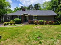 Charming single-story home with a well-maintained lawn and a combination of brick and dark siding at 423 S Rhyne St, Dallas, NC 28034