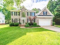 Stately brick home featuring manicured lawn and a two-car garage at 7006 Olde Sycamore Dr, Mint Hill, NC 28227