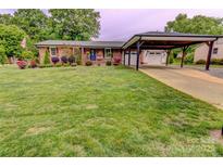 Beautiful brick home with well-manicured lawn, carport, and a charming blue front door at 800 Sunset Rd, Cherryville, NC 28021