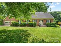 Charming brick home with manicured lawn and mature trees, offering classic curb appeal at 8017 Prince George Rd, Charlotte, NC 28210
