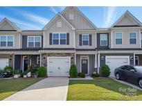 Charming townhome with a well-manicured lawn, a one car garage, and a welcoming entrance at 8018 Saluda Dr, Charlotte, NC 28269