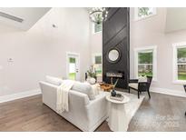 Bright living room featuring a modern fireplace, wood floors, and neutral decor at 9527 Walkers Ferry Rd, Charlotte, NC 28214