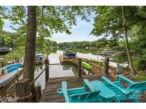 This lakeside house has a dock with a boat and kayaks at 10452 Quiet Bay Ct, Charlotte, NC 28278