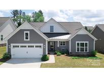Charming home featuring a gray shingle exterior, white trim, well-manicured landscaping, and a welcoming front porch at 1360 Dali Blvd, Mount Holly, NC 28120