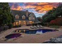Beautiful backyard with a luxurious pool, lounge chairs, and a spacious patio area, perfect for outdoor entertaining at 18823 Peninsula Cove Ln, Cornelius, NC 28031