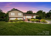 Charming two-story home featuring a landscaped yard and a blend of brick and siding at 206 Cedarwood Dr, Salisbury, NC 28147