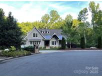 Charming home boasts a landscaped front yard with a covered porch and mature trees providing ample shade at 3201 Johnny Cake Ln, Charlotte, NC 28226