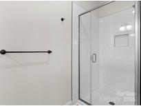 Modern bathroom features a glass-enclosed shower with white subway tile and black hardware at 3220 Riley Ave, Charlotte, NC 28269