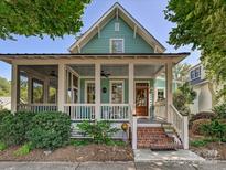 Charming home with a welcoming front porch, manicured landscaping, and a classic design at 332 Delburg St, Davidson, NC 28036